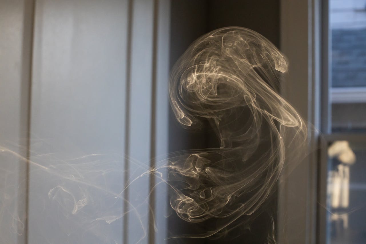 A mesmerizing swirl of smoke indoors, captured with soft focus and natural light reflection.